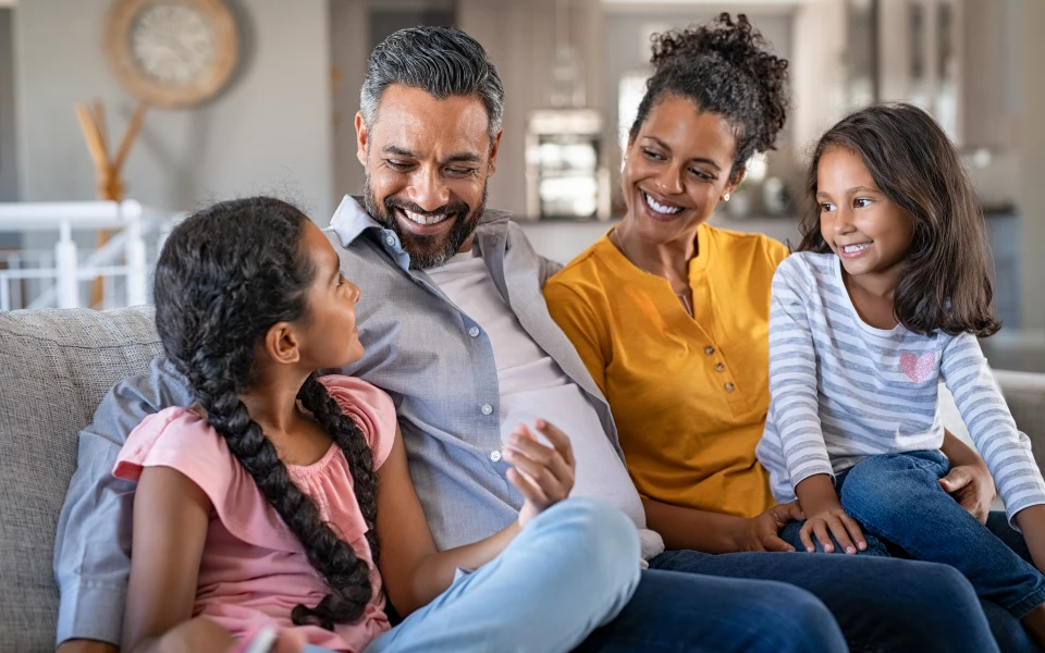 family smiling on couch