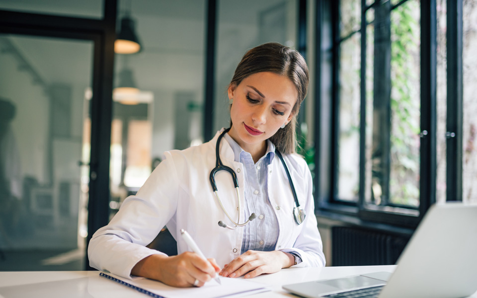 A medical professional writing notes about blood-based Alzheimer’s testing