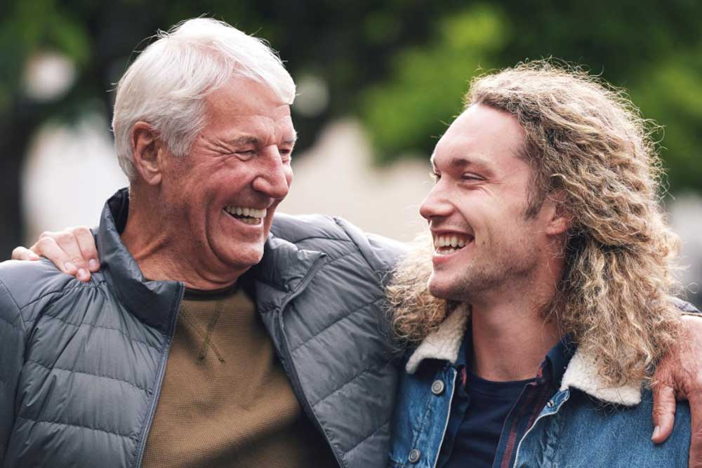 A man and his father hugging and smiling