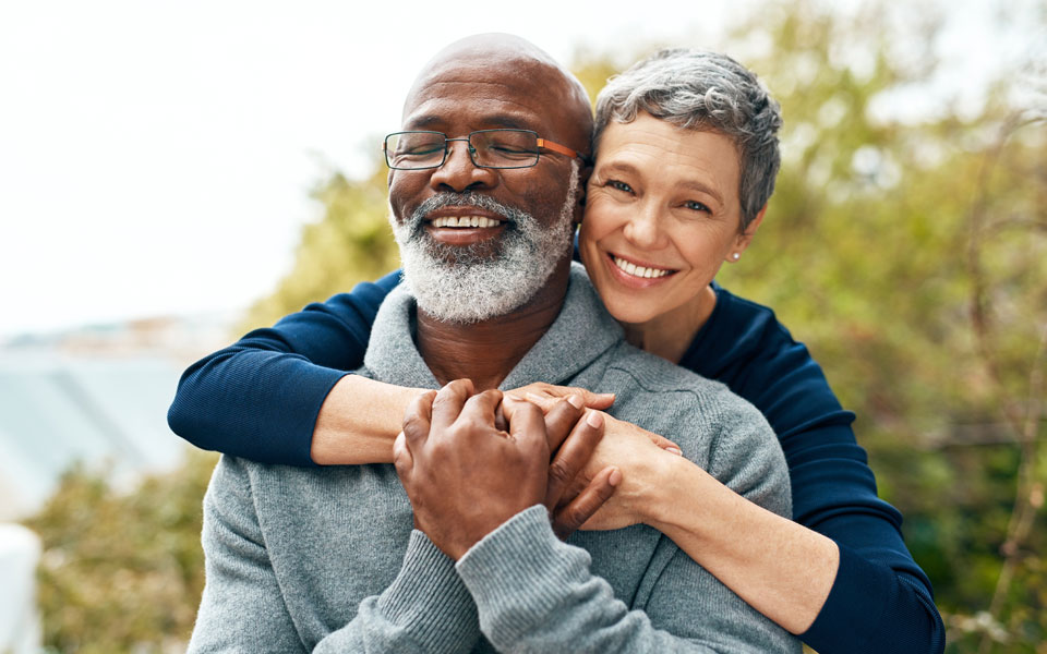 An elderly couple embracing each other