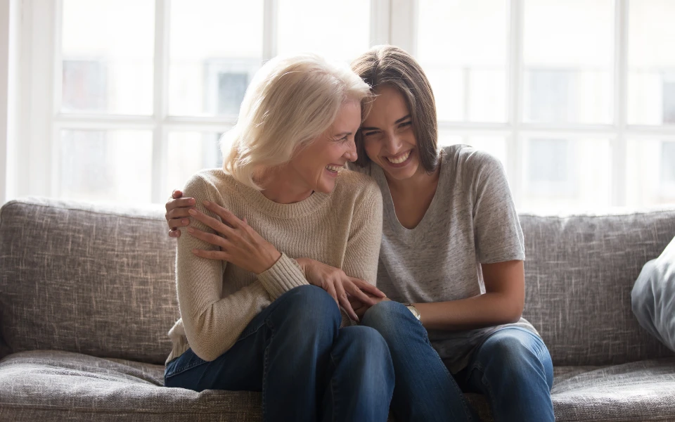 loved ones hugging and laughing on couch